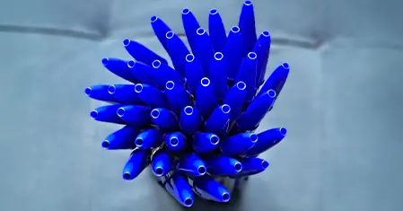 Stylos Bic bleus vides assemblés en forme de fleur, vus de dessus