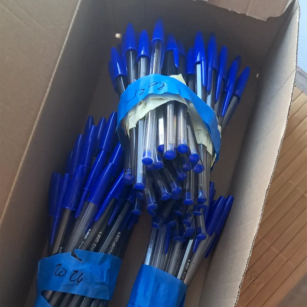 Boîte à chaussures avec des paquets de stylos Bic vides élastiqués et étiquetés par année